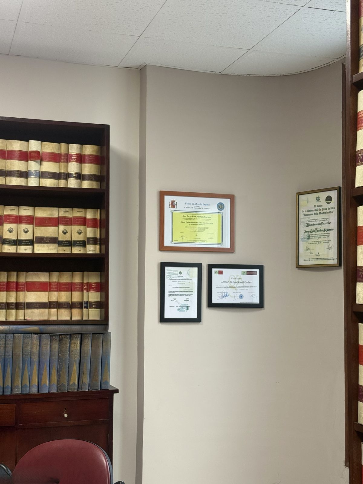 Diplomas y biblioteca jurídica en el despacho de Gestoría Dueñas